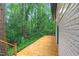 Spacious wooden deck alongside a home with white painted brick, offering a peaceful outdoor retreat surrounded by nature at 301 Lord Berkley Rd, Raleigh, NC 27610