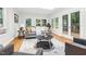 Sunlit living room featuring a cozy gray couch, round coffee table, and hardwood floors at 301 Lord Berkley Rd, Raleigh, NC 27610