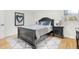 Bedroom with a dark wood bed frame, complementary bedside tables, and a cozy rug at 301 Lord Berkley Rd, Raleigh, NC 27610
