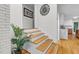 Staircase showcasing hardwood treads, white risers, and a decorative clock on the wall at 301 Lord Berkley Rd, Raleigh, NC 27610