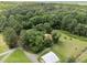 Aerial view of home surrounded by mature trees, a mix of open lawn space and forest, and a barn on the property at 3044 Rock Springs Church Rd, Creedmoor, NC 27522