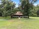 View of a home with a screened-in porch nestled among mature trees on a large lot at 3044 Rock Springs Church Rd, Creedmoor, NC 27522