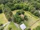 Aerial view of home surrounded by mature trees, a mix of open lawn space and forest, and a barn on the property at 3044 Rock Springs Church Rd, Creedmoor, NC 27522