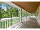 Covered porch with white columns and wood flooring overlooking a grassy yard with mature trees at 3044 Rock Springs Church Rd, Creedmoor, NC 27522