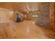 Large room featuring brick fireplace, staircase, and wood-burning stove at 3044 Rock Springs Church Rd, Creedmoor, NC 27522