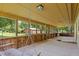 View of long screened porch with a wooden porch swing and views of the outdoors at 3044 Rock Springs Church Rd, Creedmoor, NC 27522