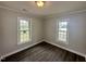 Empty bedroom offering abundant natural light from two windows, complemented by dark hardwood floors at 307 N Church St, Kenly, NC 27542