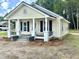 Well-maintained home featuring a classic design, front porch, and fresh landscaping in a natural setting at 307 N Church St, Kenly, NC 27542
