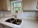 Close-up of the kitchen sink with white subway tile backsplash and stainless steel faucet at 307 N Church St, Kenly, NC 27542