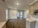 Bright, open-concept kitchen with modern cabinets, lighting, and dark-stained hardwood flooring at 307 N Church St, Kenly, NC 27542