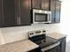 Close up view of the stainless steel microwave and oven with granite countertops at 3105 White Blossom Ct, Raleigh, NC 27610