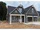 Charming home featuring a two-car garage, stone accents, gabled roof, and a welcoming front porch at 318 Abingdon Farms Dr, Selma, NC 27576