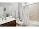 Well-lit bathroom features a single sink vanity, toilet, and a shower/tub with a patterned curtain at 33 Village Walk Dr, Chapel Hill, NC 27517