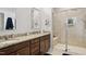 Bright bathroom featuring a double vanity with granite countertops and a tiled walk-in shower at 33 Village Walk Dr, Chapel Hill, NC 27517