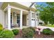 Inviting front porch with rocking chairs, beautiful landscaping, and charming details at 33 Village Walk Dr, Chapel Hill, NC 27517
