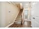 Hallway with wood floors, carpeted stairs, and a laundry room in the background at 33 Village Walk Dr, Chapel Hill, NC 27517