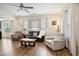Bright living room with hardwood floors, fireplace, ceiling fan, neutral paint, and a cozy seating area at 33 Village Walk Dr, Chapel Hill, NC 27517