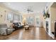Well-lit living room with hardwood floors, a fireplace, ceiling fan, and comfortable seating arrangement at 33 Village Walk Dr, Chapel Hill, NC 27517