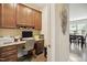 Home office featuring a built-in desk with wood cabinets, granite countertop, and view to the dining area at 33 Village Walk Dr, Chapel Hill, NC 27517