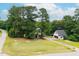 Aerial view of the home, showcasing its spacious yard, mature trees, and detached garage at 3901 Phlox Rd, Raleigh, NC 27616