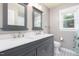 Bathroom showcasing a granite vanity with double sinks and a patterned tile floor at 3901 Phlox Rd, Raleigh, NC 27616