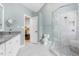 Bathroom featuring granite counters, double sinks, and a glass door shower at 3901 Phlox Rd, Raleigh, NC 27616