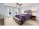 Neutral bedroom features a ceiling fan, two windows, and a bed with purple bedding at 3901 Phlox Rd, Raleigh, NC 27616