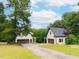 Exterior view of the home with a detached garage and lush landscaping at 3901 Phlox Rd, Raleigh, NC 27616