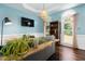 Bright living room boasts blue walls, hardwood floors, a decorative ceiling, and unique wood console table at 3901 Phlox Rd, Raleigh, NC 27616