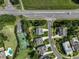 Aerial view of a residential area with manicured lawns, swimming pool, tennis court, and nearby intersection at 4104 Green Chase Way, Apex, NC 27539
