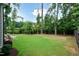 Spacious backyard featuring lush green grass and surrounded by mature trees offering a private outdoor space at 4104 Green Chase Way, Apex, NC 27539