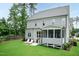 Expansive backyard view of home's exterior, patio seating, grill, screened porch and lush green lawn at 4104 Green Chase Way, Apex, NC 27539