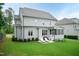 Exterior view of home showcasing a patio with seating, grill, screened porch and a sprawling lawn at 4104 Green Chase Way, Apex, NC 27539