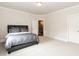 Neutral bedroom with carpet, crown molding and large bed with modern gray bedding set at 4104 Green Chase Way, Apex, NC 27539