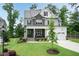 Charming two-story home featuring stone accents, a covered porch, and a lush green lawn at 4104 Green Chase Way, Apex, NC 27539