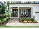 Welcoming front porch with stone columns, rocking chairs, and decorative landscaping at 4104 Green Chase Way, Apex, NC 27539