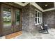 Cozy front porch with stone accents, rocking chairs, and a welcoming entryway with double doors at 4104 Green Chase Way, Apex, NC 27539