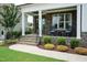 Inviting front porch featuring stone accents, comfortable seating, and neatly trimmed landscaping at 4104 Green Chase Way, Apex, NC 27539