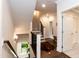 Hallway featuring hardwood floors, a staircase with dark railings, and natural light from a nearby window at 4104 Green Chase Way, Apex, NC 27539