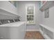 Bright laundry room with appliances, shelving, window, and neutral decor at 416 Fred Tew Rd, Dunn, NC 28334