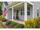 Inviting front porch area with columns, American flag, and well-maintained landscaping at 416 Fred Tew Rd, Dunn, NC 28334