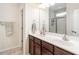 Bright bathroom featuring a double sink vanity with dark wood cabinets and a glass-enclosed shower at 4179 Dunkirk Dr, Burlington, NC 27215