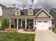 Charming home featuring dormers, a covered porch, and a well-manicured front yard at 4179 Dunkirk Dr, Burlington, NC 27215