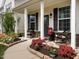 Welcoming front porch with stone accents and colorful flower beds bordering the walkway at 4179 Dunkirk Dr, Burlington, NC 27215