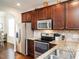 Beautiful kitchen featuring stainless steel appliances, granite counters, and rich, dark cabinets, ideal for cooking and gathering at 4179 Dunkirk Dr, Burlington, NC 27215