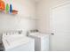 Convenient laundry room with white washer and dryer, shelving for storage, and a door at 4179 Dunkirk Dr, Burlington, NC 27215