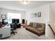 Comfortable office with computer and desk setup, a cozy sofa, and a bright window at 4179 Dunkirk Dr, Burlington, NC 27215
