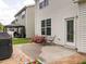 Back patio area with a view of the home's back door, landscaping, and black table set at 4179 Dunkirk Dr, Burlington, NC 27215