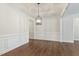 Bright dining room featuring hardwood floors, wainscoting, and a stylish light fixture at 45 Glen Bend Ct, Spring Lake, NC 28390