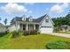 Inviting one-story home with light blue siding, dormer windows, and a two-car garage under a bright blue sky at 45 Glen Bend Ct, Spring Lake, NC 28390